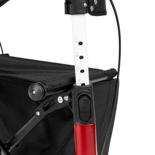 Close-up of a red and black handle on a stroller with measurement scale.